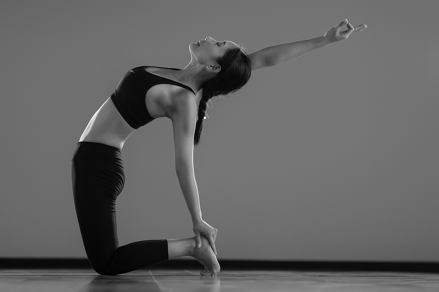 Grayscale yoga backbend pose, arm extended upward